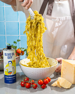 Person serving pasta with a can of olive oil  guy and Parmesan cheese on a kitchen counter.