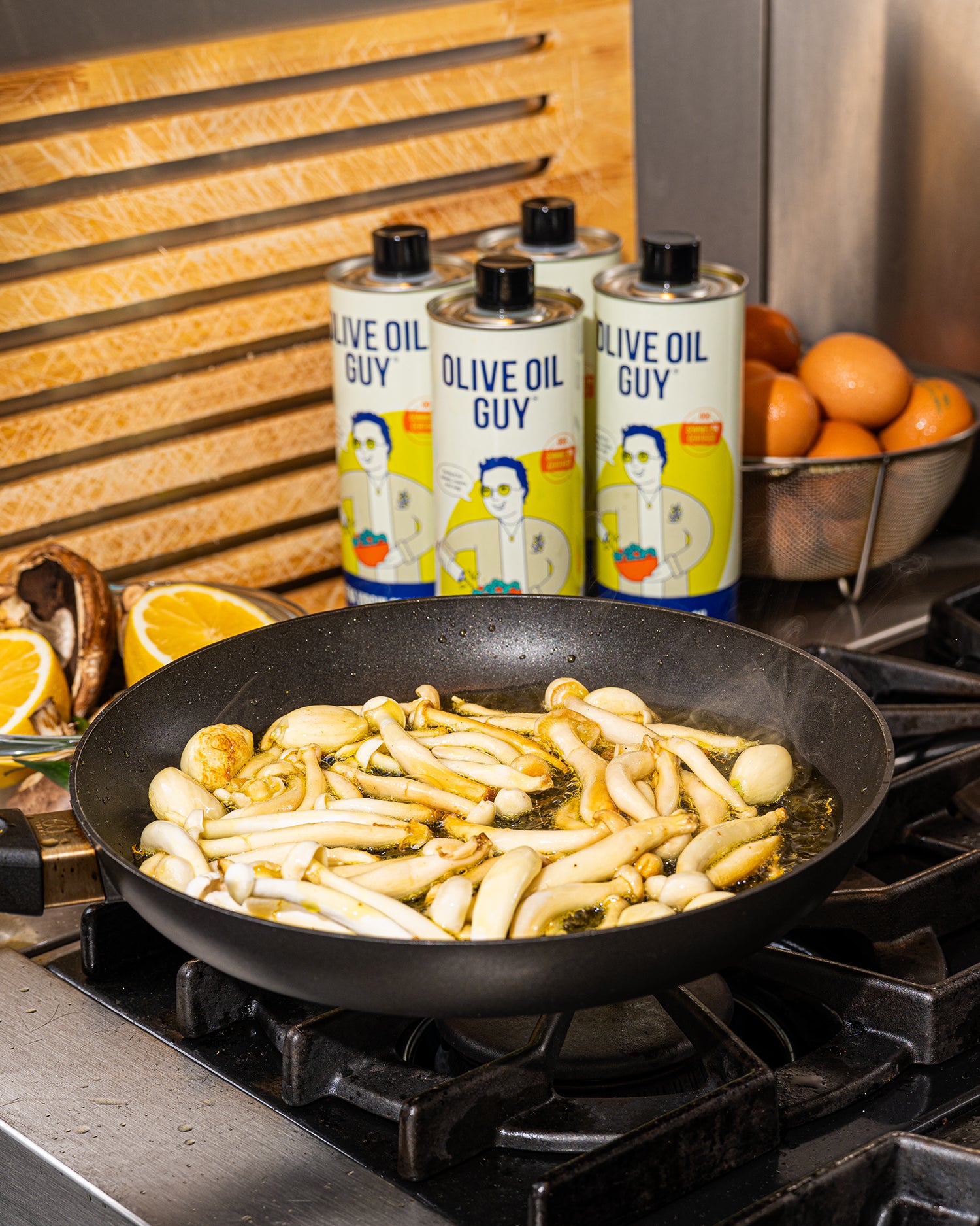 Olive oil cooking with 'Olive Oil Guy' bottles in the background
